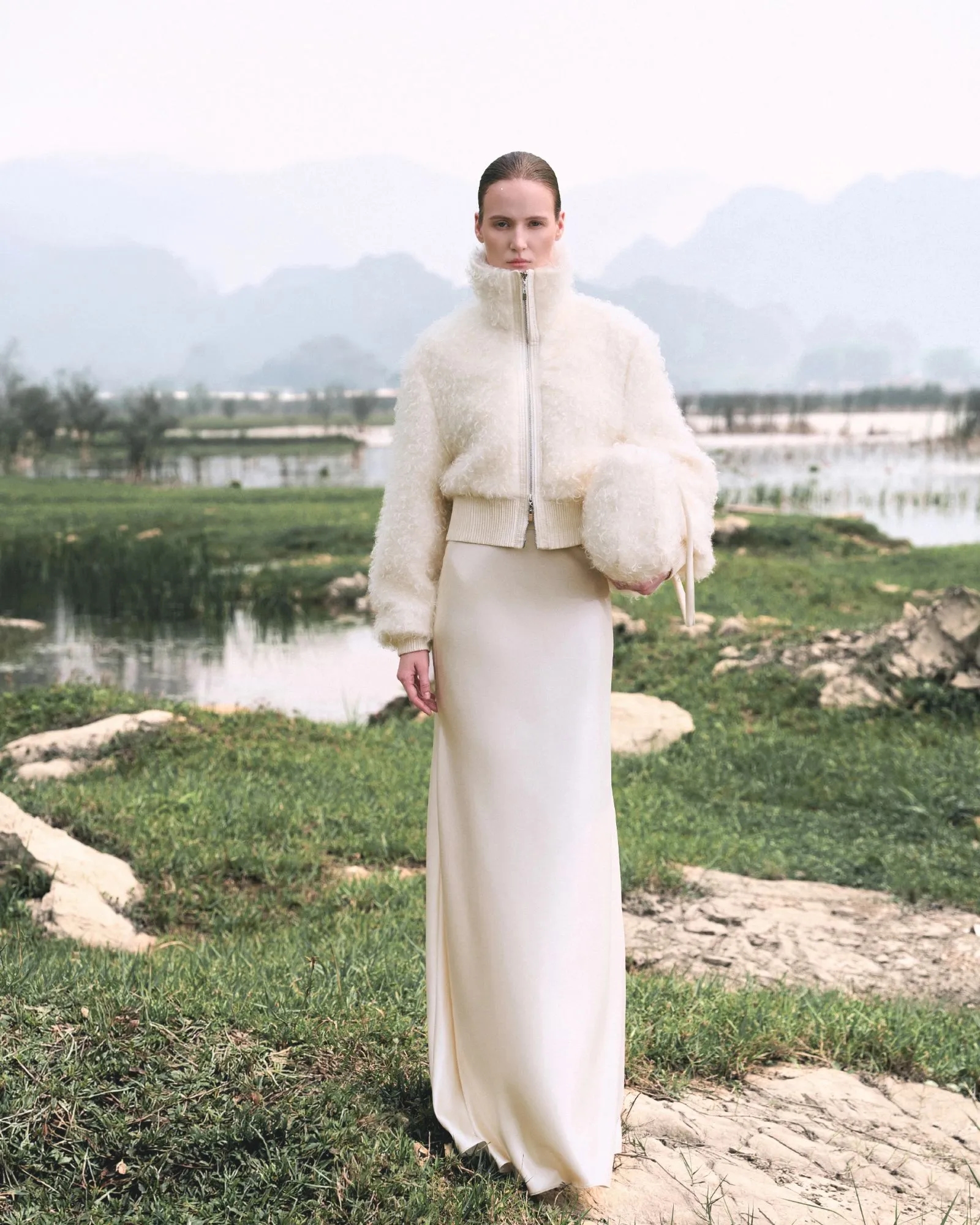 TEMPO REVERSO AW’26 campaign: model in an ivory WHITE ANT look in a natural landscape